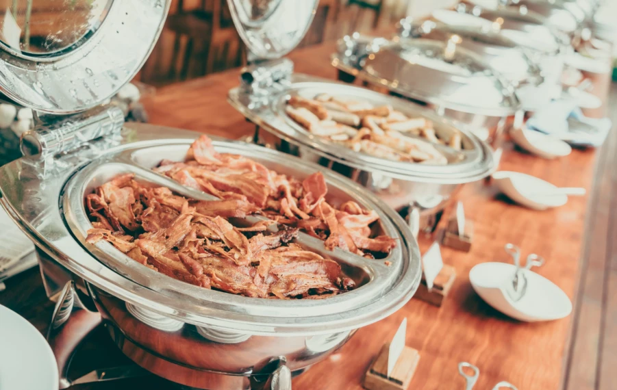 Svadobný polnočný bufet s kapustnicou, mäsom, pečivom a finger food, pri ktorom si hostia po polnoci pochutnávajú